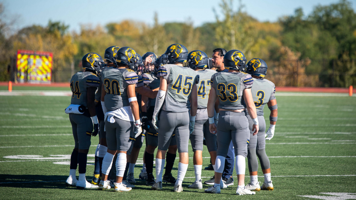 Pride football special teams players huddled around head coach Miguel Regalado
