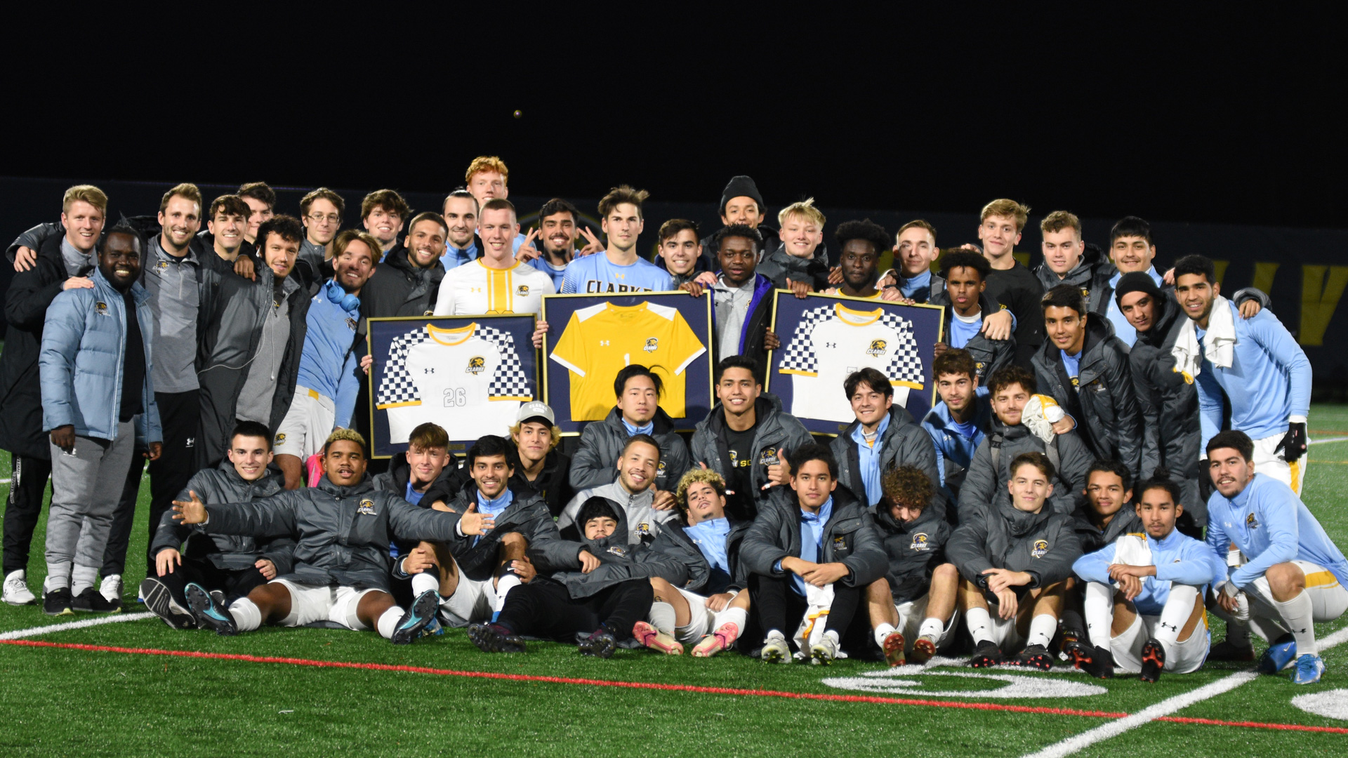 Clarke men's soccer team grouped around their three seniors on senior night