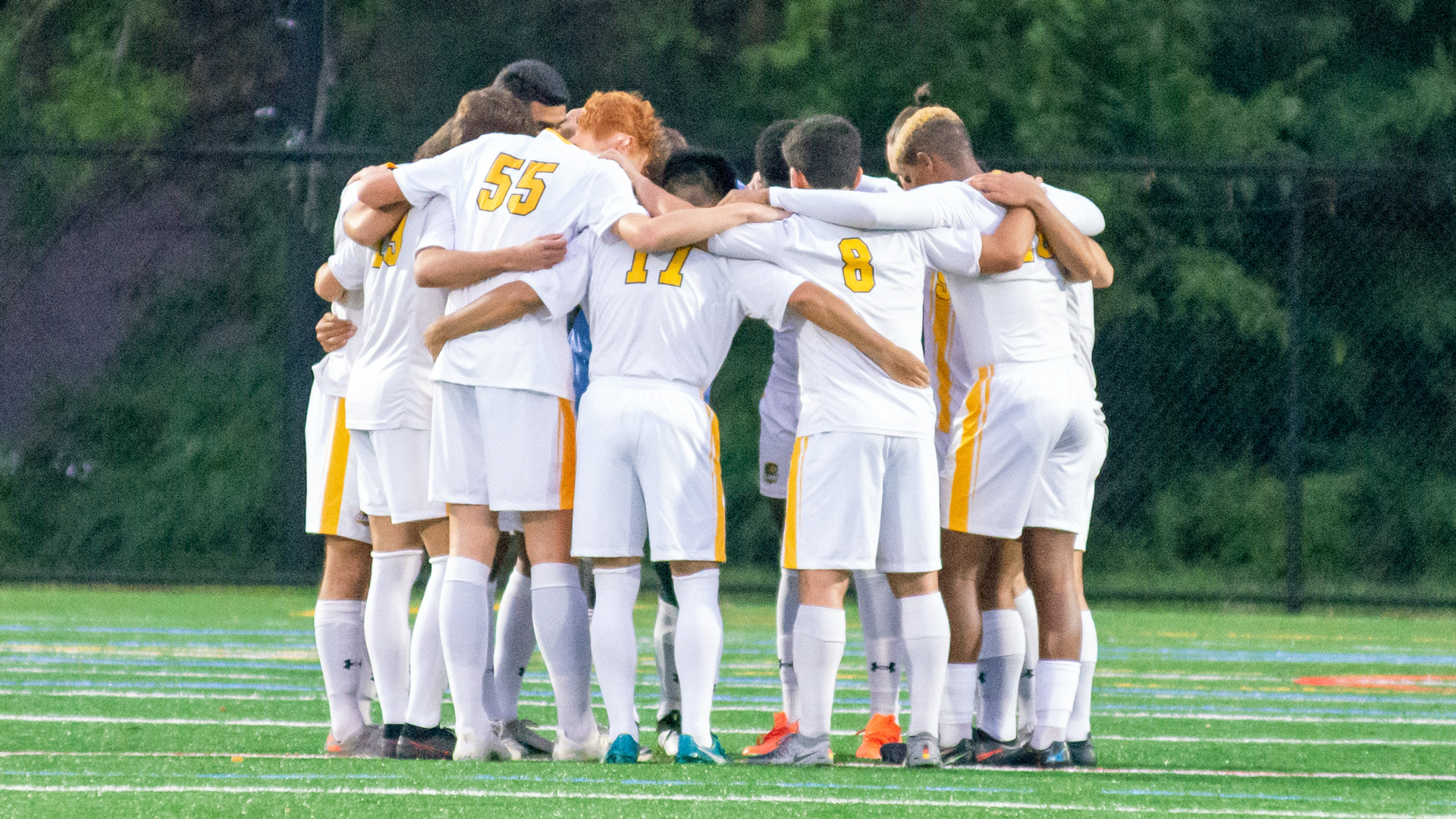 Clarke men's soccer huddled up on the field